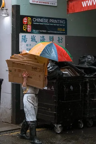 穿着黑色靴子拿着纸箱的人