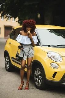站在黄色菲亚特500l旁边的女人