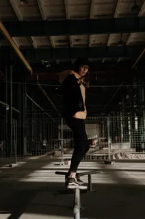 一名男子站在路轨上，穿着黑色面包车和旧的Skool高帮上衣