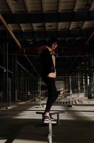 一名男子站在路轨上，穿着黑色面包车和旧的Skool高帮上衣