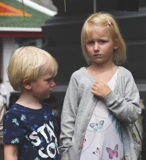 男孩穿着蓝色和白色的Stay Cool Print圆领T恤，女孩穿着白色和青色蝴蝶印花圆领T恤和灰色开襟长袖开衫