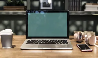 在手机和耳机附近拍摄Macbook的特写照片