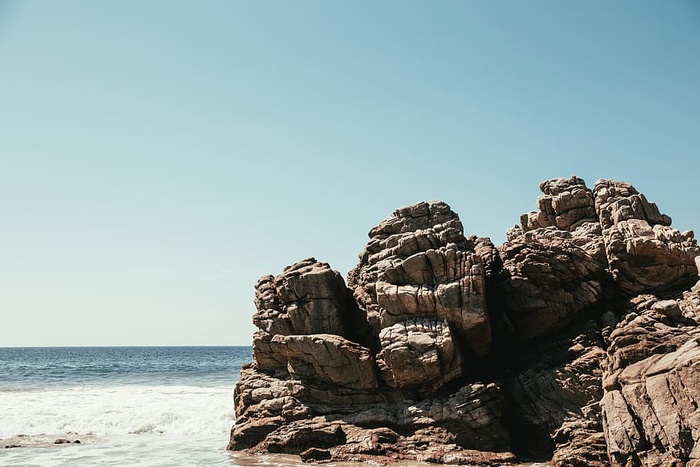 海浪冲击着海滩上的一块大岩石