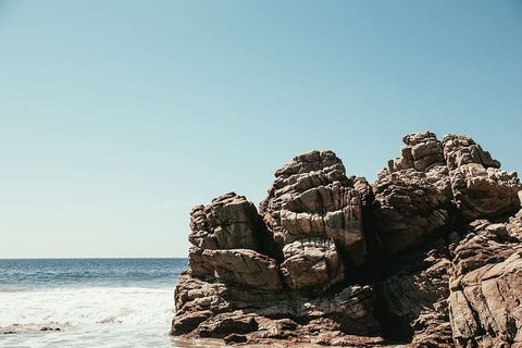 海浪冲击着海滩上的一块大岩石