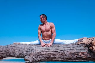 男子在棕色原木上劈腿