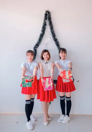 三个女人拿着礼品盒站着