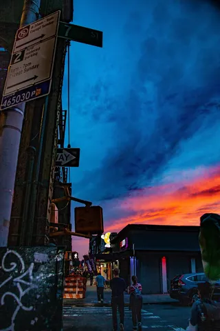 人们在蓝色和红色的天空下行走