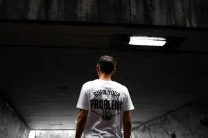 身穿黑白烧伤问题印花T恤的男子