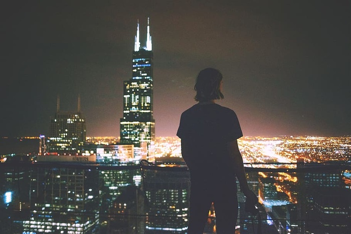 一个在夜晚欣赏城市全景的男人