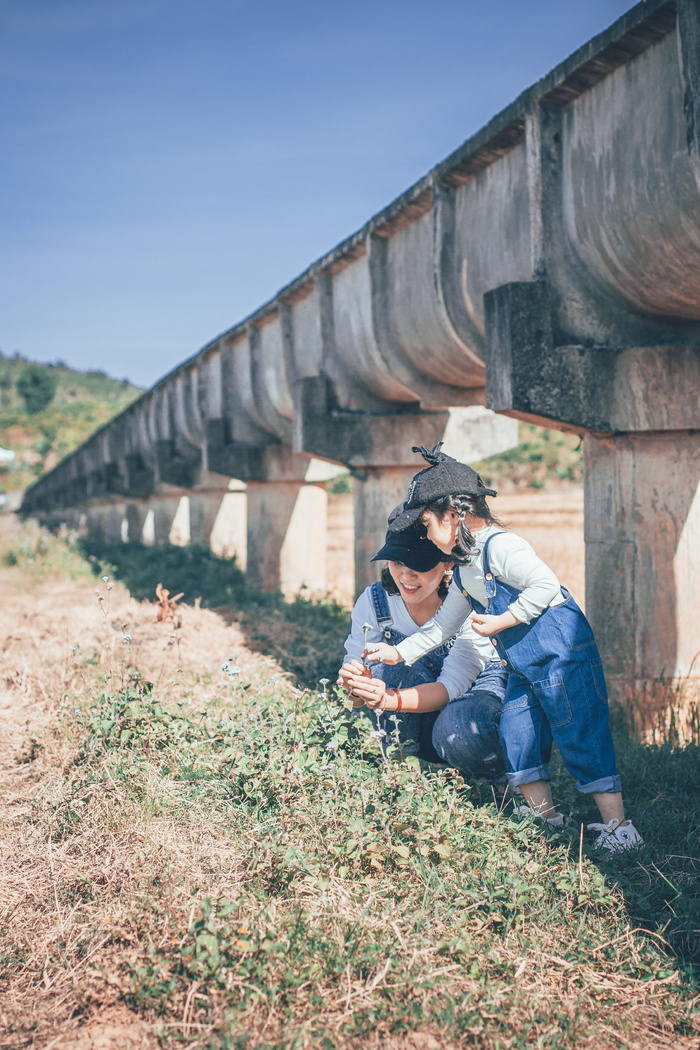 坐在女孩旁边的女人站在户外的绿草上