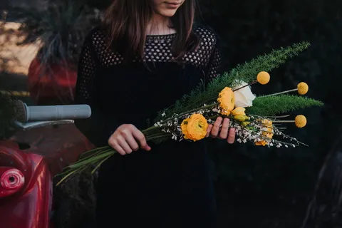 拿着白色和黄色花束的女人 拿着白色和黄色花束的女人