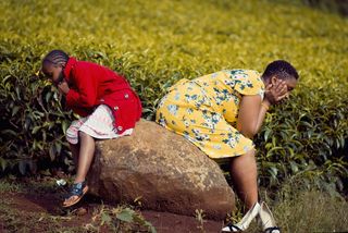 坐在棕色岩石上的女孩和女人