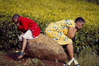 坐在棕色岩石上的女孩和女人