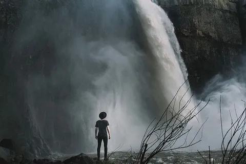 站在瀑布附近的男孩