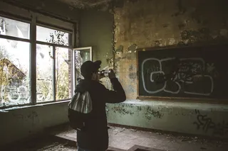 一名男子白天在教室里用智能手机谈论黑板的照片