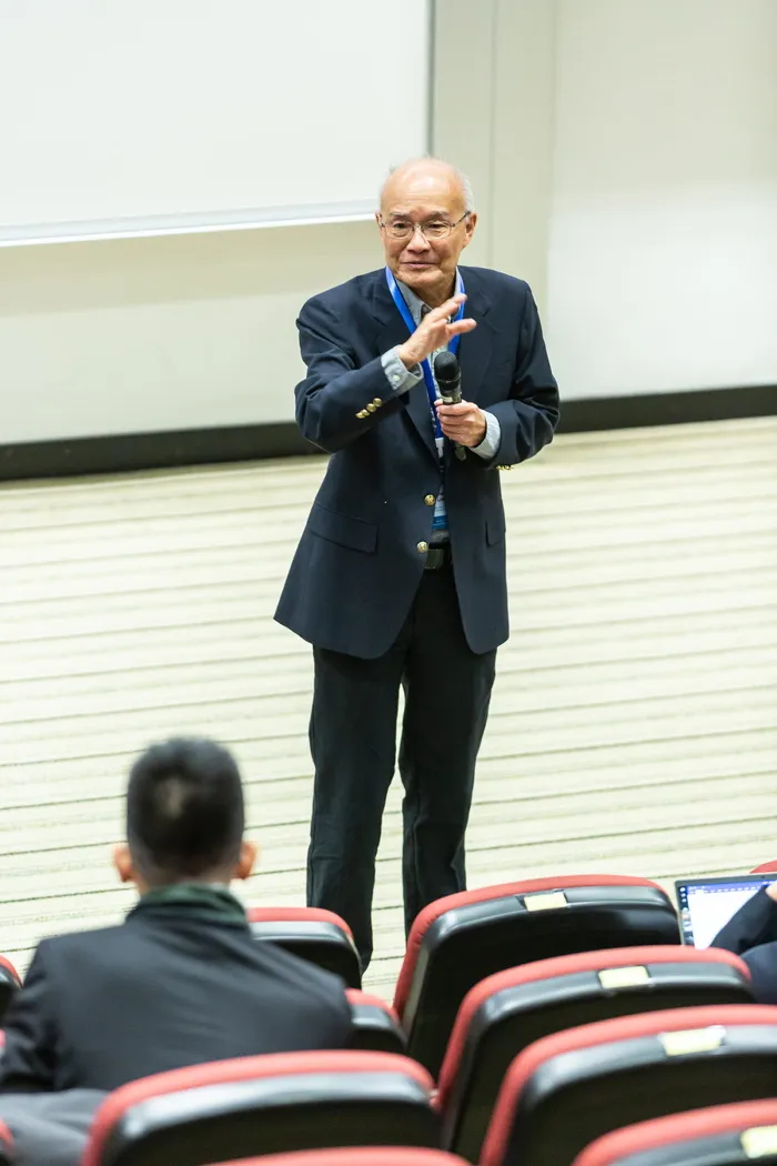 站在椅子和人前面的人
