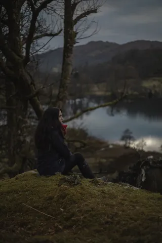 白天穿着黑夹克坐在地板上的女人