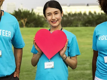 微笑的女人拿着红色的心形切口 微笑的女人拿着红色的心形切口