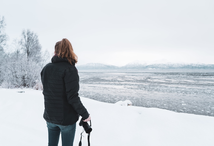 穿黑夹克的女人站在雪地上