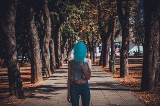 站在树下灰色小路上的女人