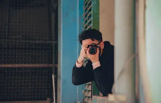 拿着黑色单反相机的人