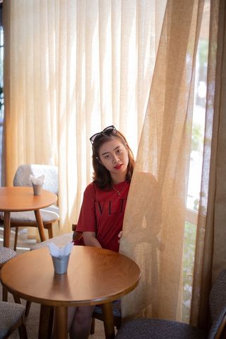 坐在窗帘后面的女人