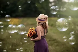 身穿紫色连衣裙的女子手持向日葵