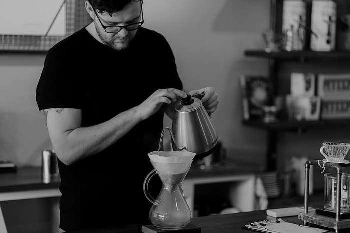 男子在茶壶上倒液体