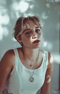 穿着白色上衣靠近白色油漆墙的女人