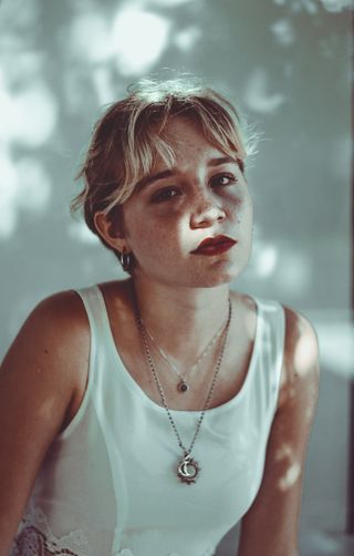 穿着白色上衣靠近白色油漆墙的女人