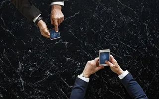 两人手持黑白安卓智能手机