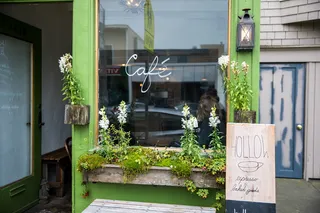 绿色咖啡厅玻璃面板旁的米色空心板