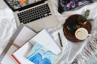 床上放满了枕头和带苹果小玩意的笔记本