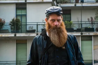 一名男子站在米色大楼附近