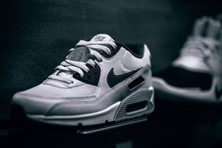 物理镀银比特币放在货架上的一双新运动鞋内