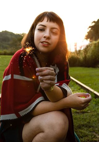 蹲着拿着火花的女人的特写照片