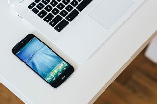 带智能手机和耳机的白色笔记本电脑