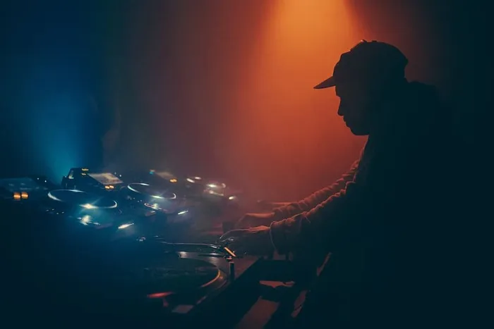 在俱乐部里操作音乐混音台的DJ