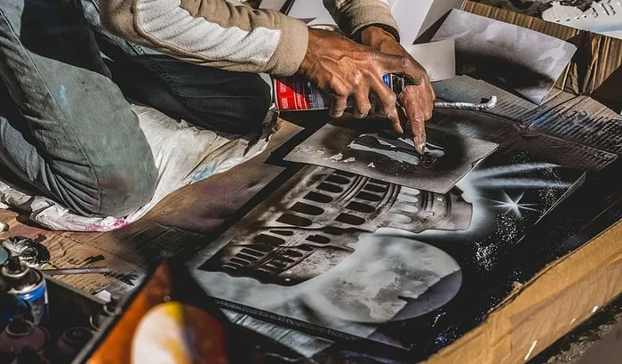 一个人用左手食指指着桌子上的一张混凝土建筑打印的照片