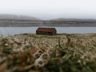 白天在河边有一个棕色的小屋