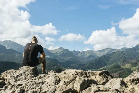 坐在山脉岩石上的人