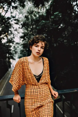 靠在栏杆上的女人的选择性聚焦摄影