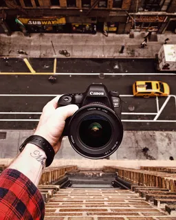 窗外拿着黑色佳能EOS 6D的人 窗外拿着黑色佳能EOS 6D的人