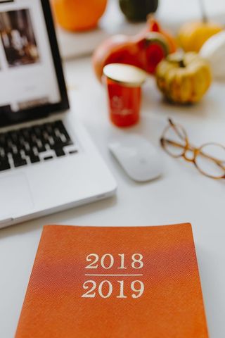 带橙色笔记本和南瓜的女性书桌