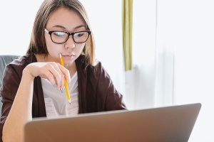 年轻女子在笔记本电脑上思考和观察