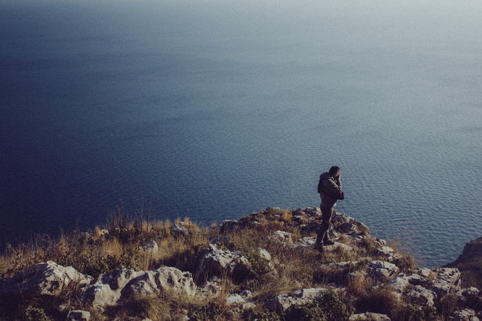 在水体附近穿着夹克的男子照片