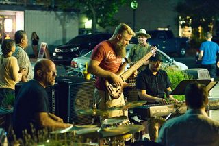 拿着棕色电吉他的人