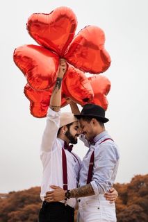 一名男子拿着气球面对另一名男子