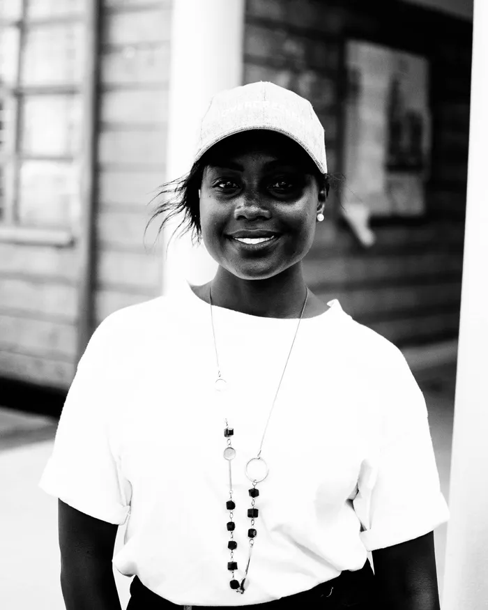 站着微笑的女人的灰度照片