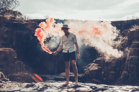 手持烟雾弹的站立男子